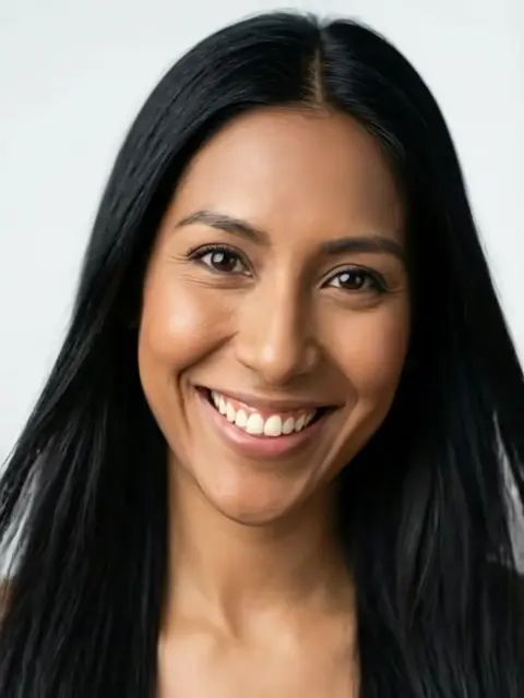 Milena 20, Mujer de 30 años de piel trigueña, cabello negro y ojos marrones oscuros, sonrisa cálida y mirada impactante.